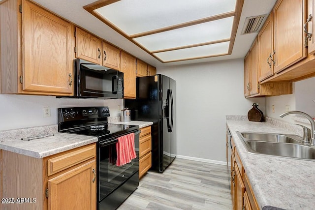 kitchen featuring sink, light hardwood / wood-style flooring, and black appliances