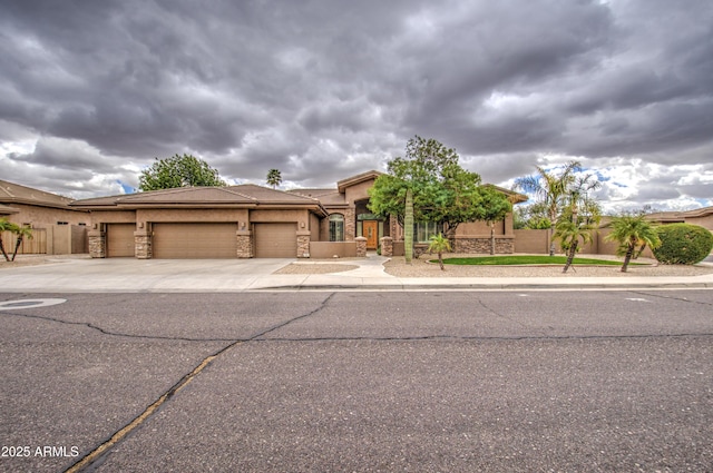 view of front of home featuring a garage, concrete driveway, stone siding, and stucco siding