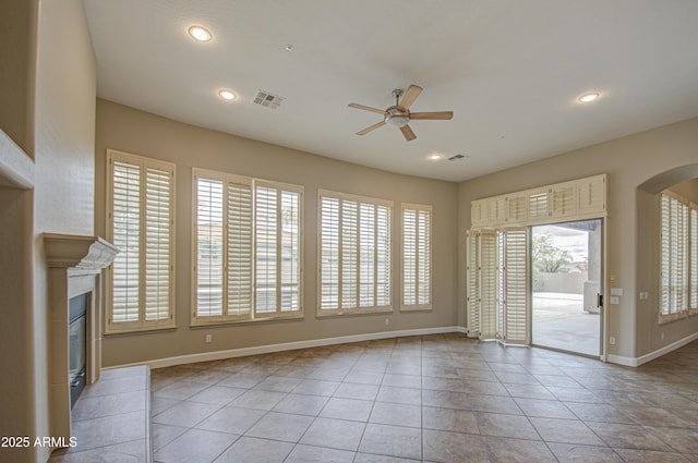 unfurnished living room with arched walkways, a glass covered fireplace, visible vents, and recessed lighting