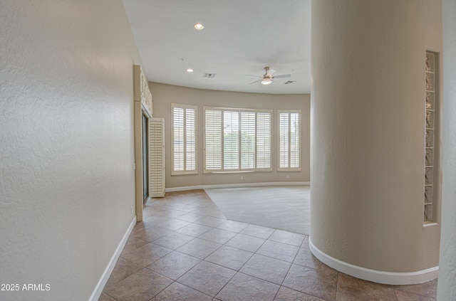 tiled spare room with recessed lighting, visible vents, a textured wall, a ceiling fan, and baseboards