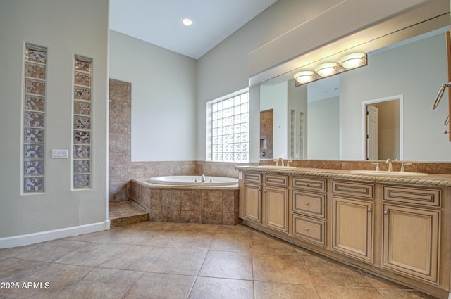 full bath with double vanity, a garden tub, a sink, and tile patterned floors