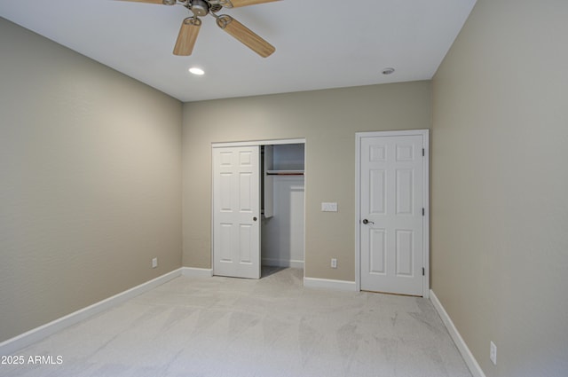 unfurnished bedroom with a closet, light carpet, ceiling fan, and baseboards