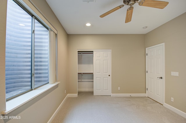 unfurnished bedroom with light carpet, a closet, and baseboards