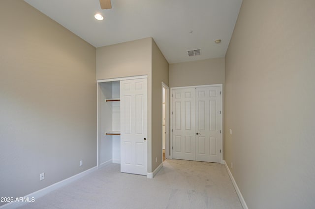 unfurnished bedroom with carpet flooring, visible vents, and baseboards