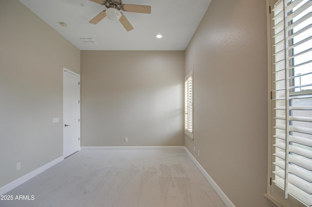 empty room with light colored carpet, a wealth of natural light, visible vents, and baseboards