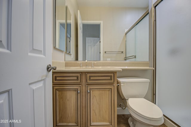 full bathroom featuring vanity, a shower stall, and toilet