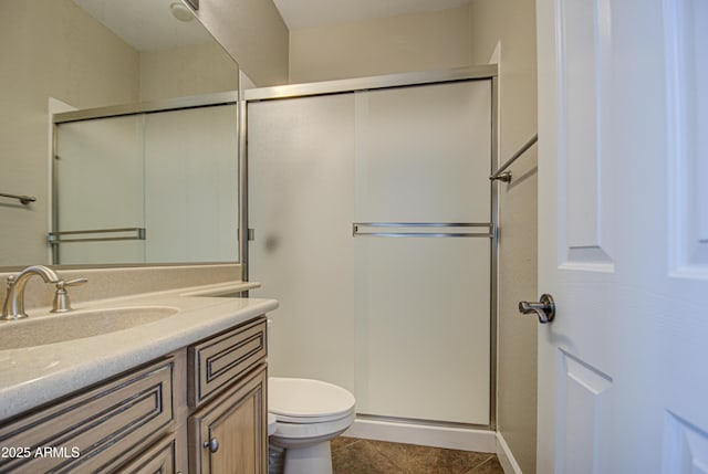 bathroom featuring a shower with shower door, vanity, toilet, and tile patterned floors