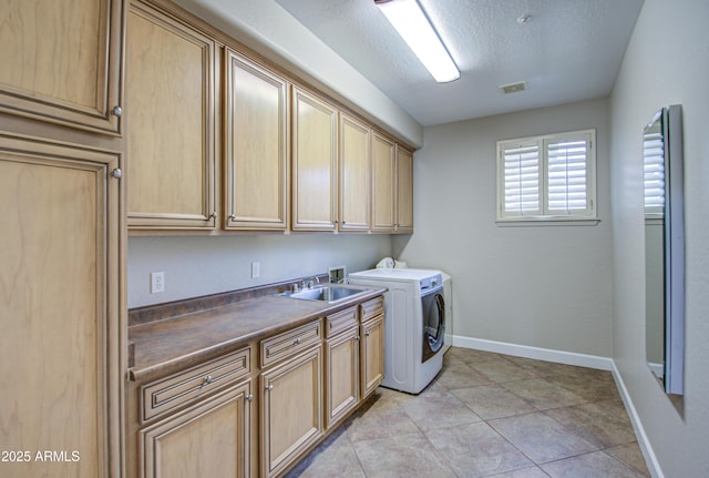 laundry area with cabinet space, baseboards, a textured ceiling, separate washer and dryer, and a sink