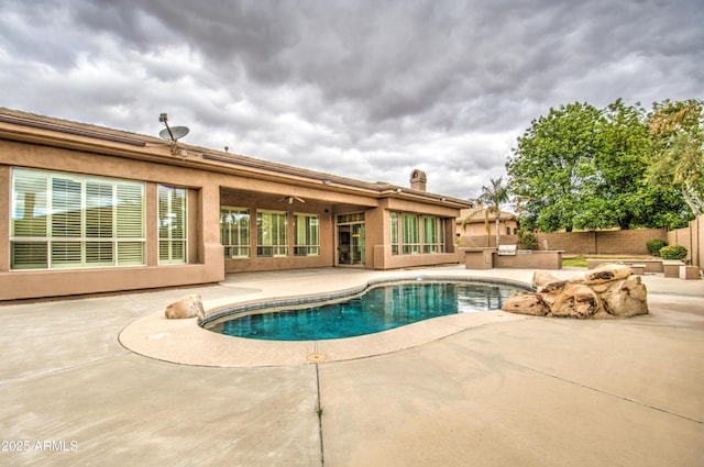 view of pool with ceiling fan, a patio, exterior kitchen, and fence