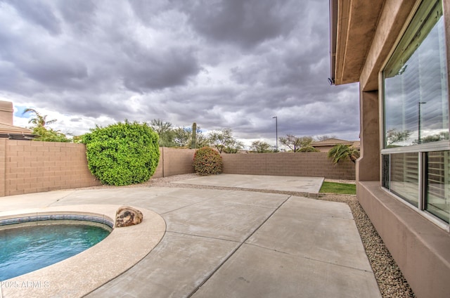 view of swimming pool with a fenced backyard and a patio