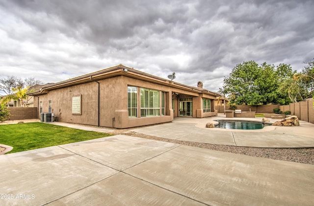 back of property with a fenced backyard, a patio, central AC, and stucco siding