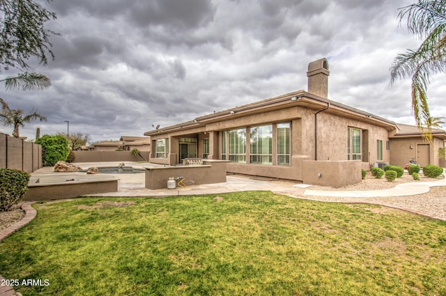 back of property featuring an outdoor kitchen, a lawn, a fenced backyard, a patio area, and stucco siding