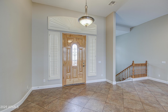 tiled foyer entrance featuring visible vents and baseboards