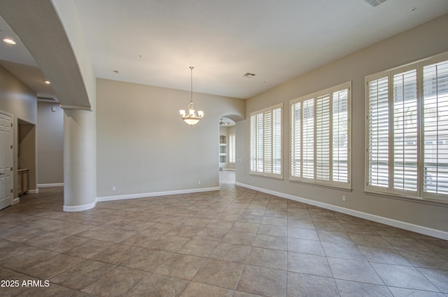 interior space with an inviting chandelier, visible vents, baseboards, and arched walkways