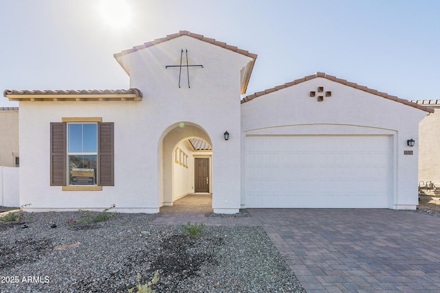 16367 W Desert Mirage Dr, Surprise, AZ 85388 - mediterranean / spanish house featuring stucco siding, a tiled roof, decorative driveway, and a garage