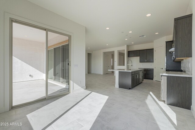 16367 W Desert Mirage Dr, Surprise, AZ 85388 - kitchen with stainless steel gas cooktop, a sink, a center island with sink, recessed lighting, and light countertops