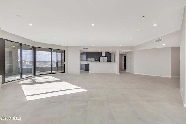 unfurnished living room featuring baseboards, visible vents, and recessed lighting