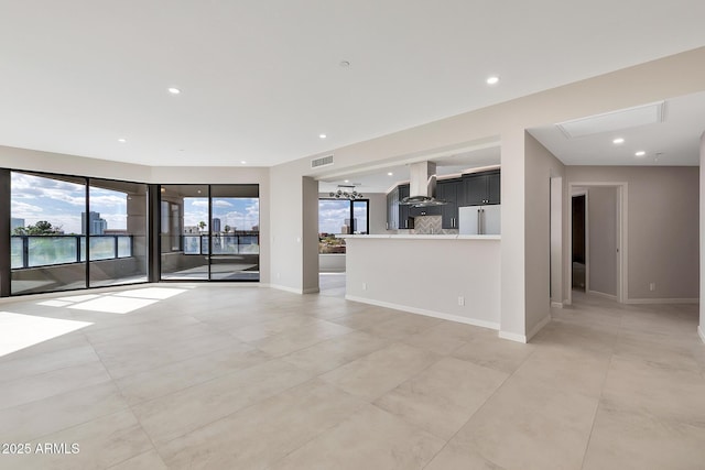 unfurnished living room with visible vents, baseboards, and recessed lighting