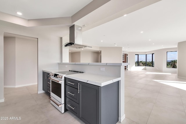 kitchen featuring recessed lighting, light countertops, electric range, wall chimney range hood, and baseboards