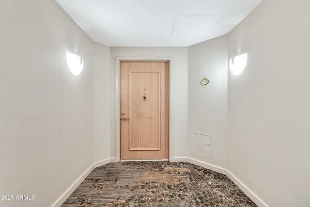 doorway featuring wood finished floors and baseboards