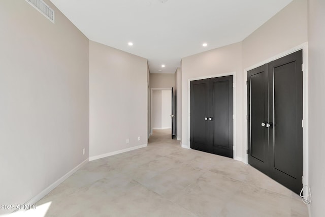 unfurnished bedroom featuring baseboards, visible vents, multiple closets, and recessed lighting