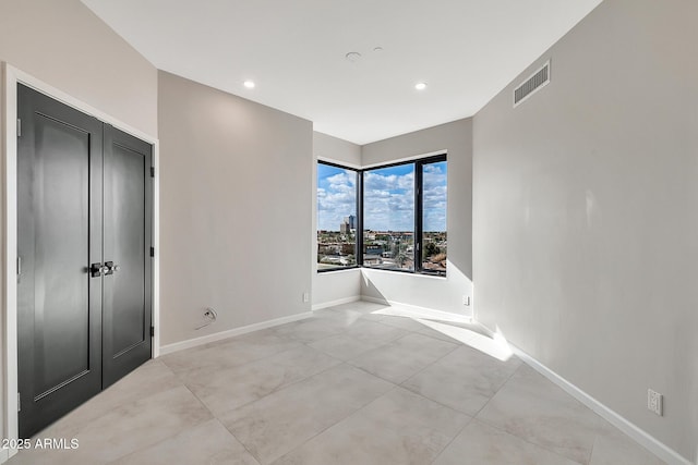 spare room with recessed lighting, visible vents, and baseboards