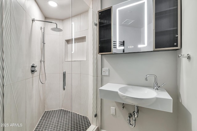 full bathroom featuring a stall shower and a sink