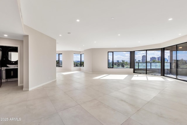 spare room with baseboards, light tile patterned floors, and recessed lighting