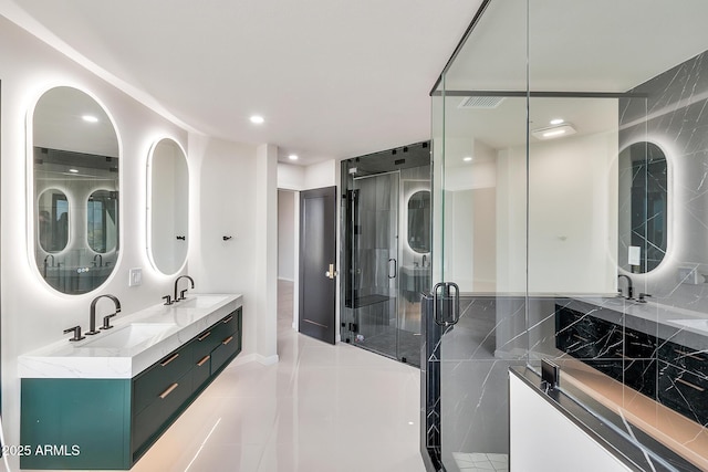 bathroom featuring double vanity, a shower stall, and a sink