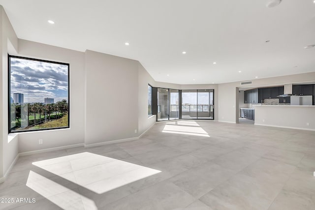 unfurnished living room with visible vents, baseboards, and recessed lighting