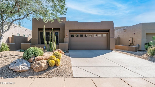 pueblo-style house featuring a garage