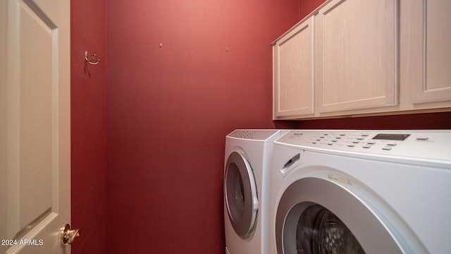 laundry area with washer and clothes dryer and cabinets