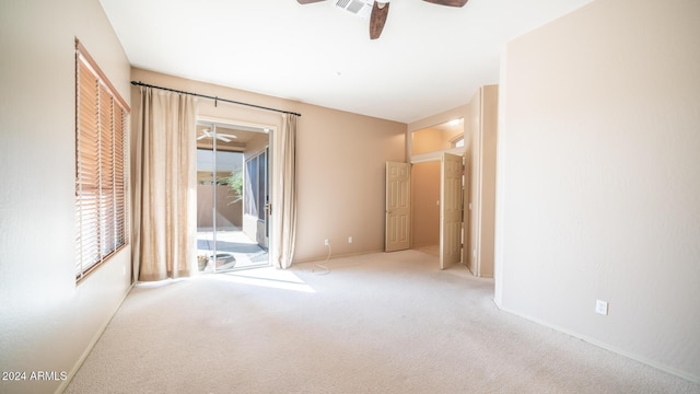 carpeted spare room featuring ceiling fan