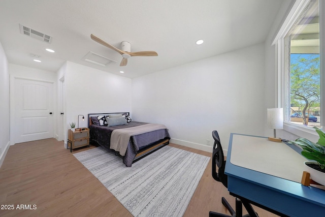 bedroom featuring wood finished floors, ceiling fan, visible vents, and baseboards