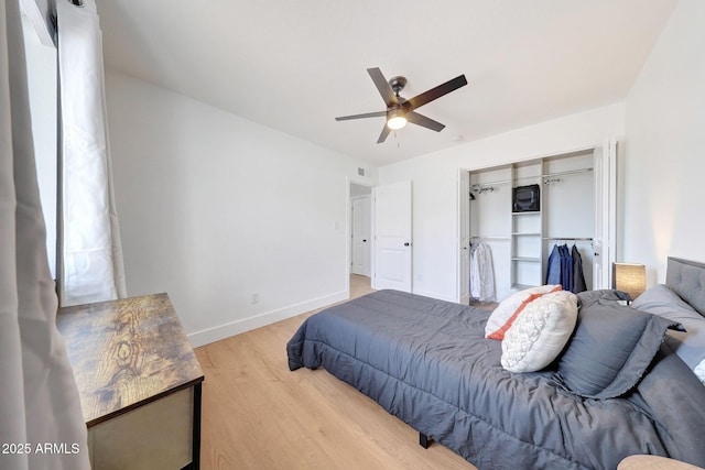 bedroom with visible vents, a closet, baseboards, wood finished floors, and a ceiling fan
