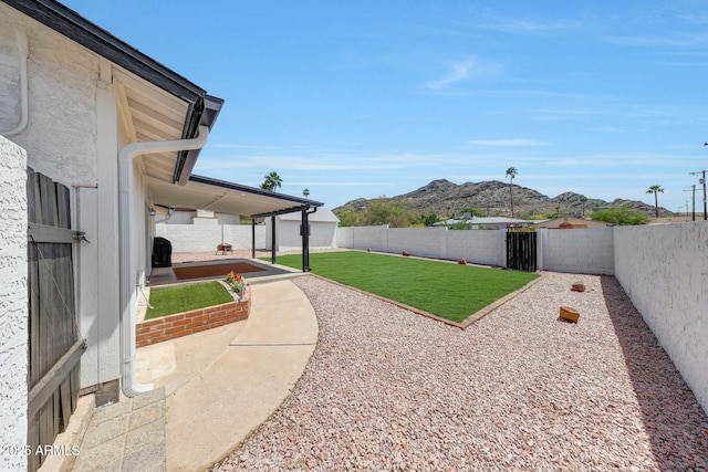 view of yard featuring a mountain view, a fenced backyard, and a patio area
