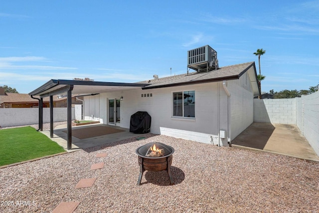 rear view of property with an outdoor fire pit, a patio, central AC, and a fenced backyard