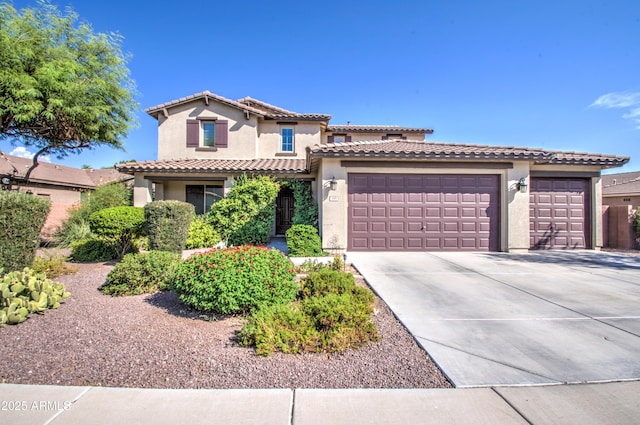 mediterranean / spanish-style home with stucco siding, a garage, driveway, and a tile roof