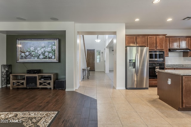 kitchen featuring visible vents, under cabinet range hood, light stone counters, recessed lighting, and appliances with stainless steel finishes