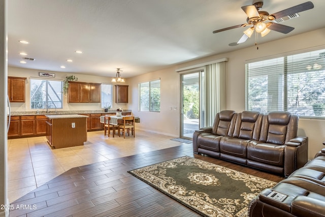 living area featuring baseboards, recessed lighting, visible vents, and ceiling fan