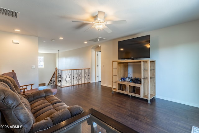 living room with baseboards, wood finished floors, visible vents, and ceiling fan