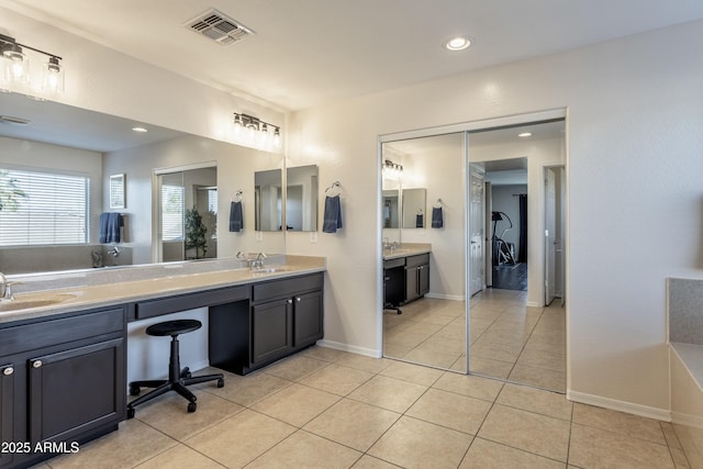 full bath with tile patterned flooring, double vanity, visible vents, and a sink