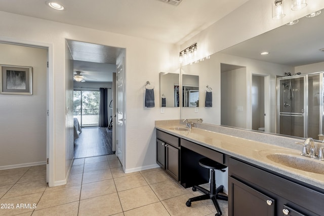 full bath featuring a sink, double vanity, a shower stall, and tile patterned flooring