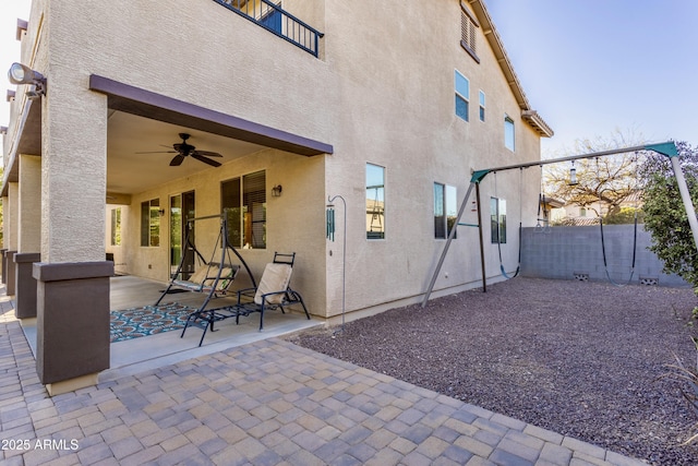 view of patio / terrace with ceiling fan and fence