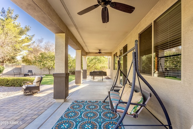 view of patio with outdoor dining space, fence, and ceiling fan