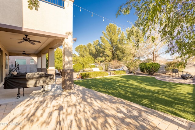 view of patio with a ceiling fan, a fenced backyard, and an outdoor fire pit