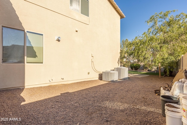 view of yard featuring central AC unit and fence