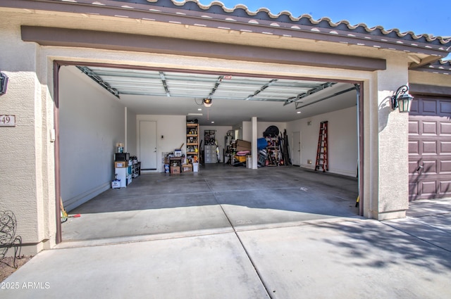 garage with a garage door opener and concrete driveway