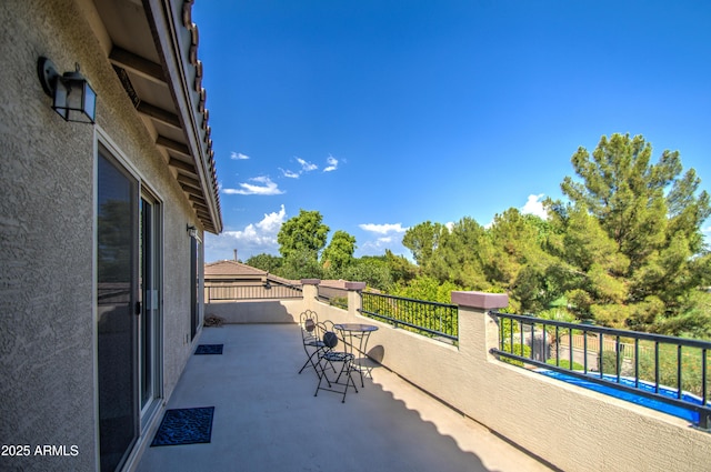 view of patio / terrace with a fenced in pool and a balcony