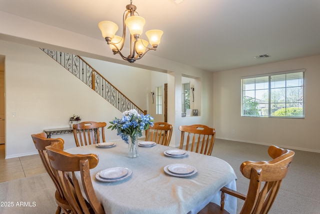 dining space featuring visible vents, baseboards, stairway, an inviting chandelier, and tile patterned floors